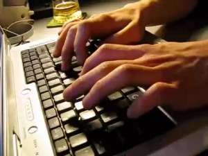 Photo of hands typing on a laptop keyboard